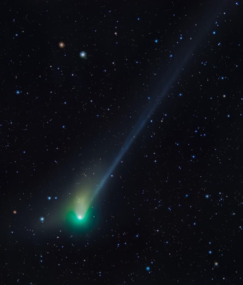 Bright green comet in sky with stars