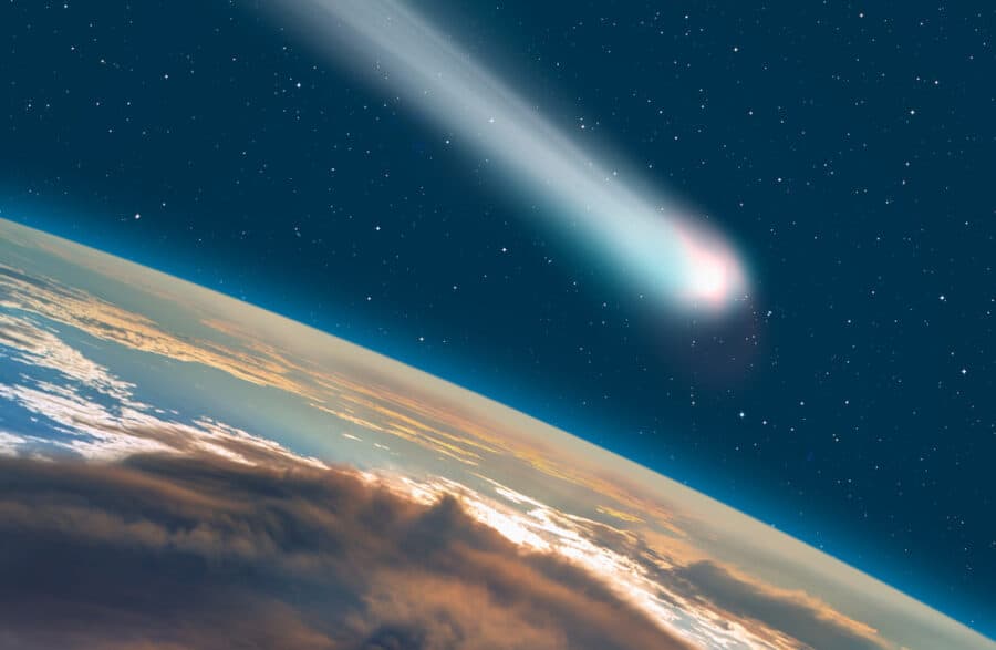 Comet streaking through space with Earth in the background.